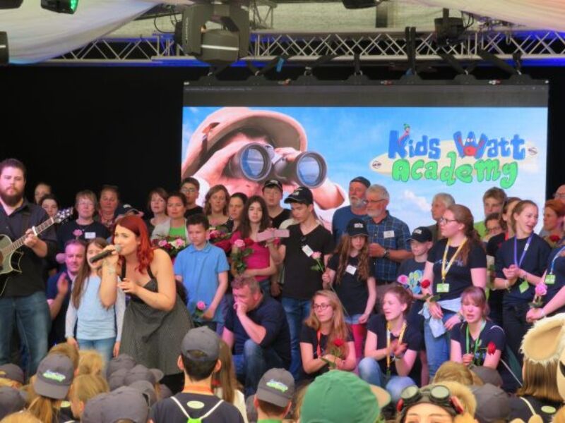 Kinder stehen auf der Bühne bei der Kids Watt Academy, Spaß